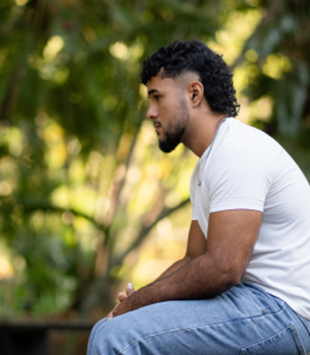 Male in white shirt sitting and reflecting